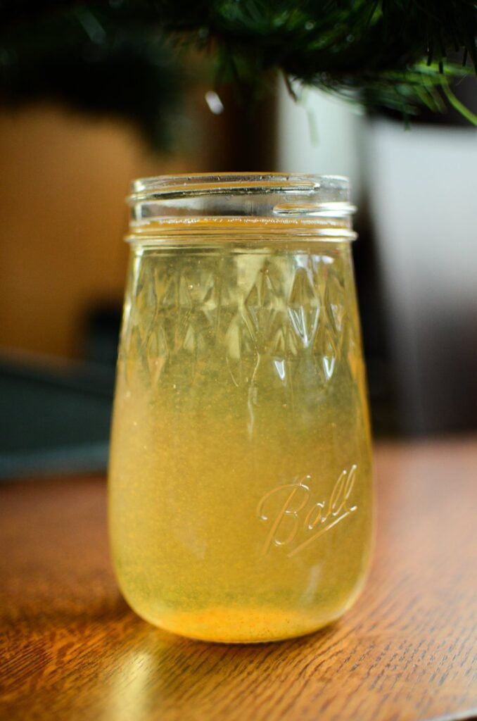 Mulled apple cider syrup mixed with sparkling water in a Ball Flute Jar.